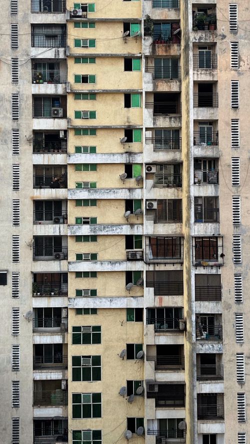 Free Close-up view of a high-rise residential building facade with multiple windows and balconies. Stock Photo