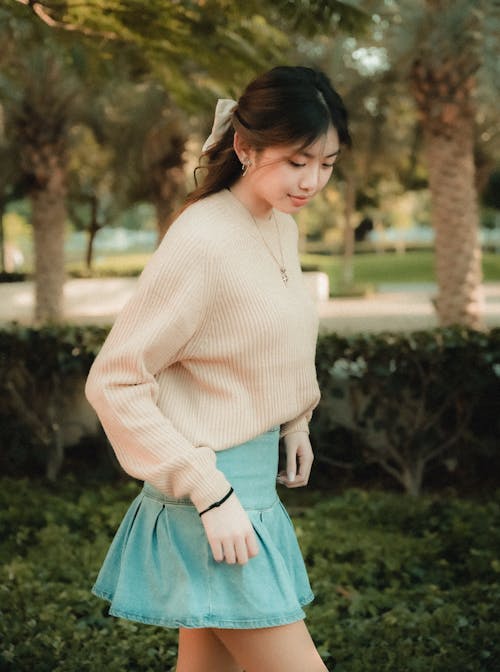 A woman in a sweater and skirt walking