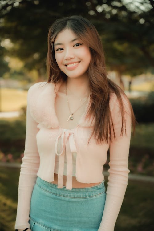 A young woman in a pink sweater and skirt