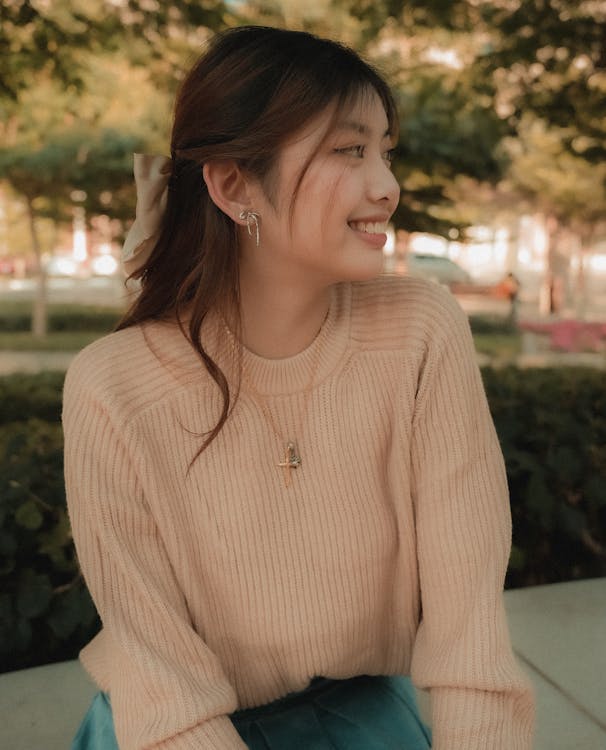 A woman smiling while sitting on a bench