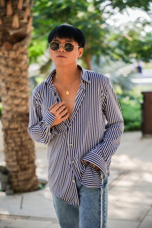 A man in a striped shirt and sunglasses