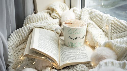 A book, a cup of coffee and a ball of yarn