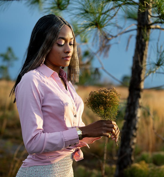 A woman in a pink shirt is looking at something