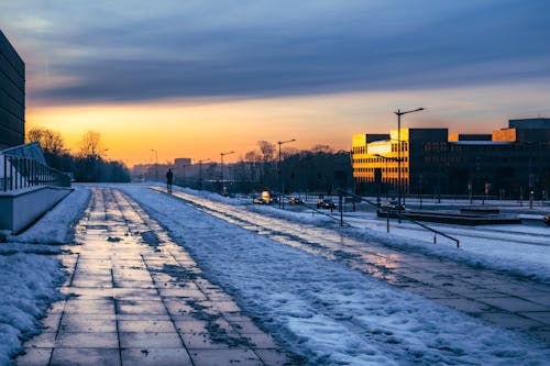 Snow on Sidewalk in City at Sunset