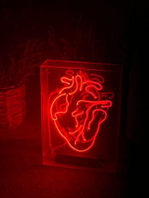Free A striking red neon anatomical heart light adds drama and style to modern home decor. Stock Photo