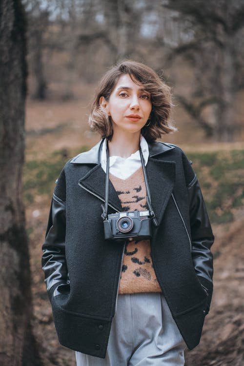 Brunette Woman with Camera Posing in Park