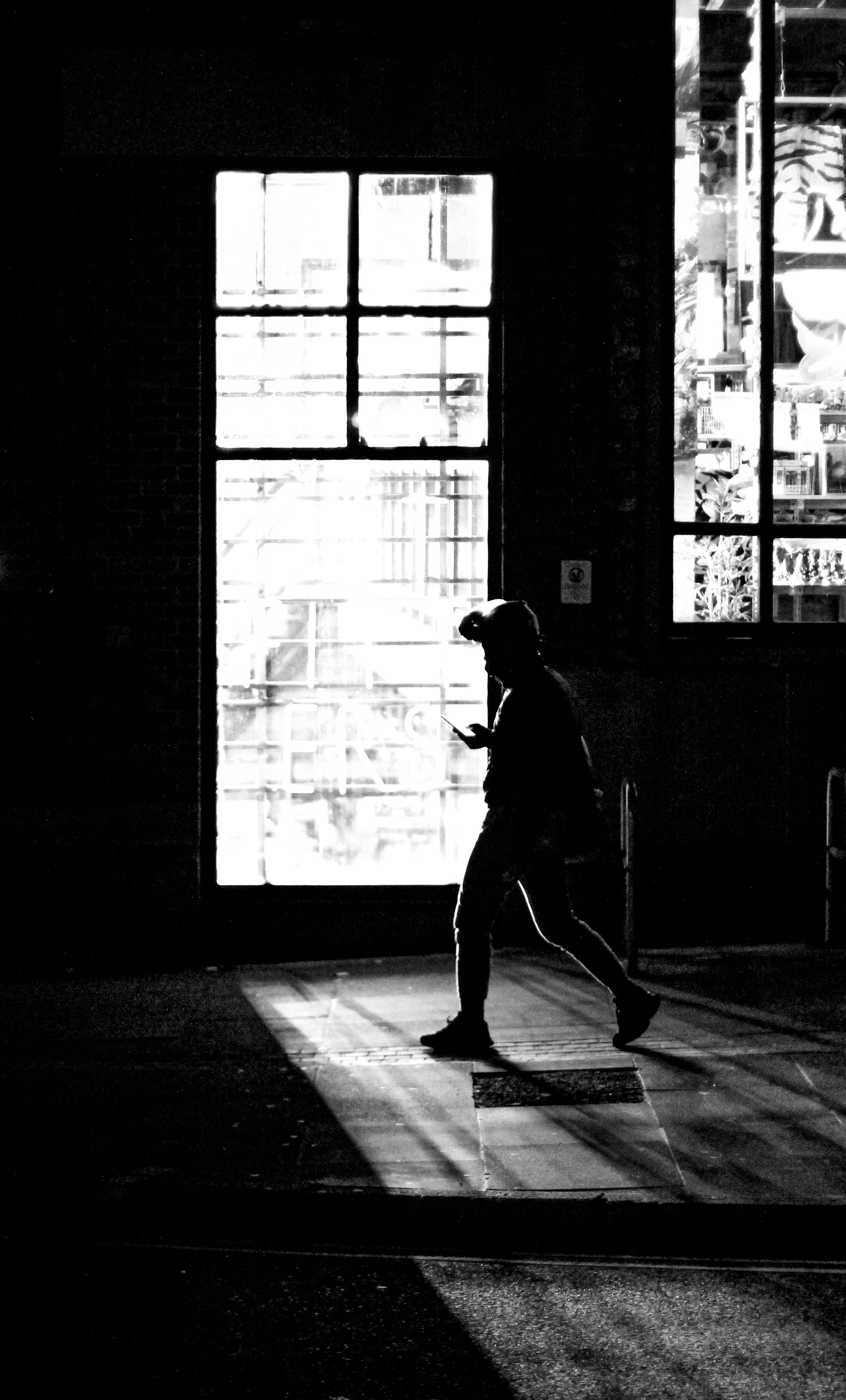 Silhouette of Pedestrian Walking by Window · Free Stock Photo