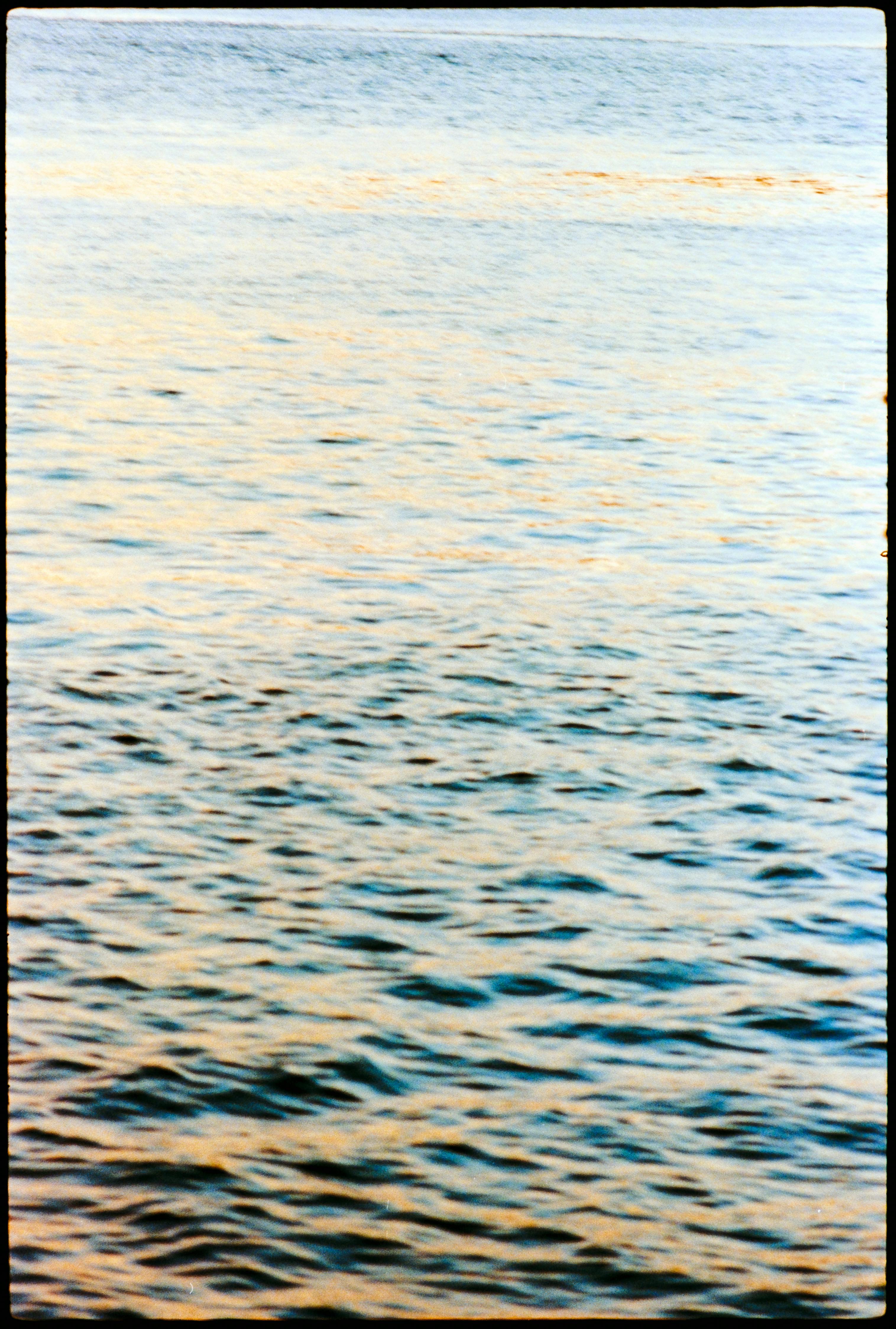 Tranquil rippling ocean waves captured during a golden hour in Lisbon.