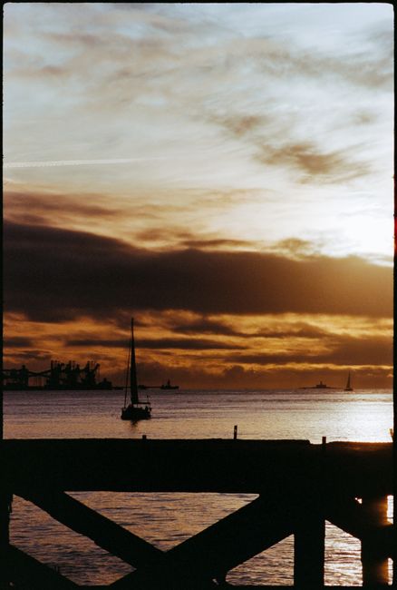 A tranquil scene of a sailboat silhouetted against a Lisbon sunset, highlighting calming waters and dramatic skies.