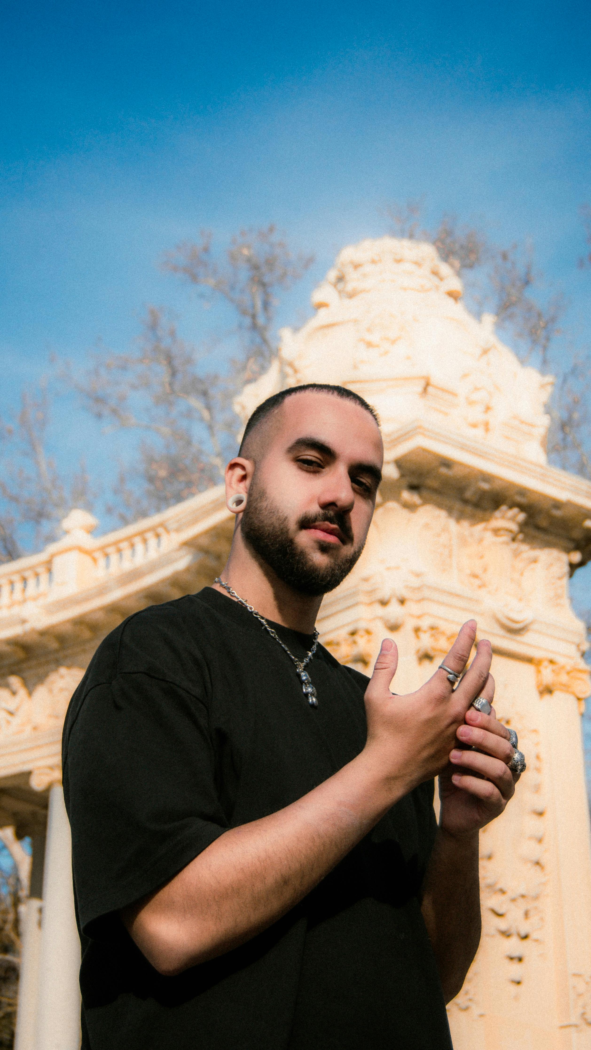 Man posing in front of historic architecture in Madrid, Spain.