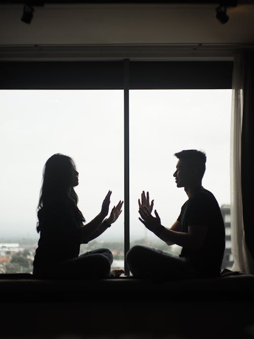 Silhouettes of a Man and Woman Sitting by the Window 