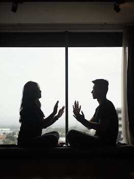 Silhouette of a couple sitting by a window, creating a peaceful and intimate atmosphere.