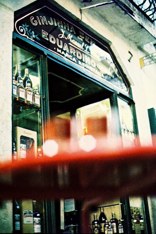 A red table with a glass of wine in front of a store