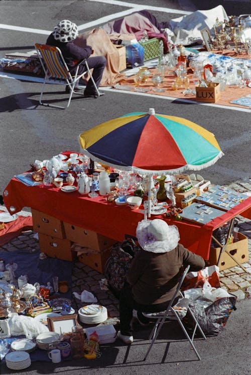 A woman sits on a chair at a flea market