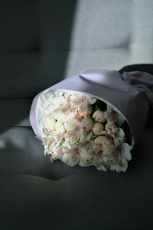 A bouquet of white flowers sitting on a couch