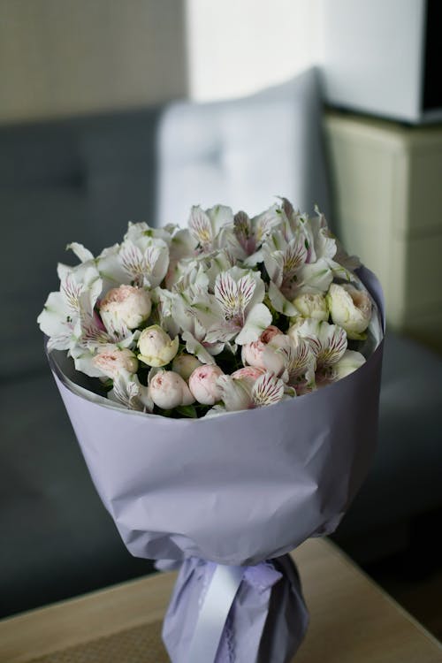 A bouquet of white and pink flowers sitting on a table
