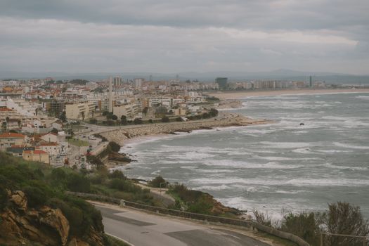 A scenic view of Figueira da Foz city along the Atlantic coast with waves crashing on the shoreline.