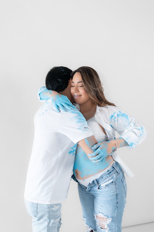 Couple in Blue Paint Hugging 