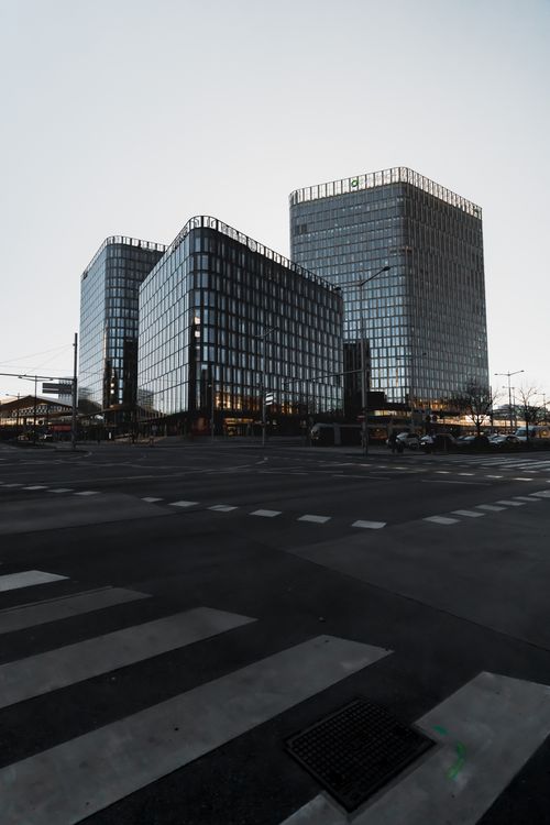 Free Contemporary glass office buildings reflecting a clear sky at an empty intersection. Stock Photo