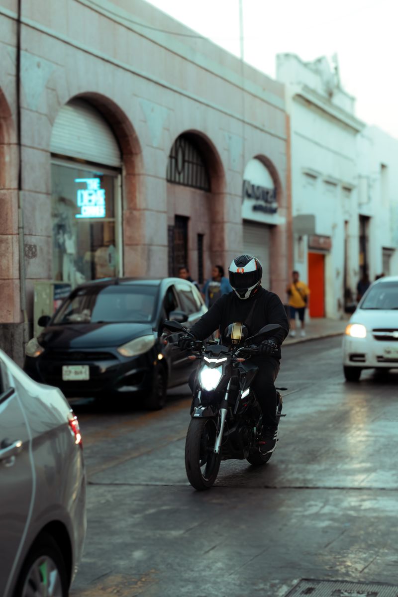 A motorcyclist rides through a bustling city street