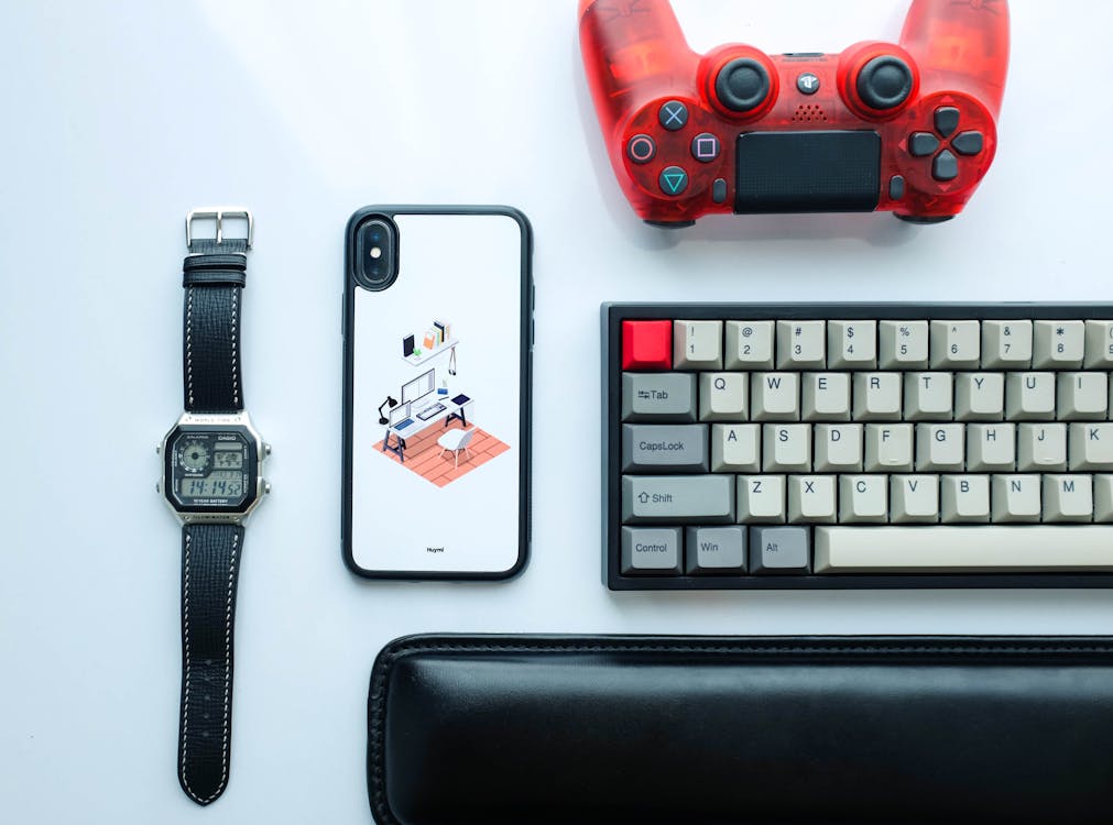 Fotografi Flat Lay Dari Dualshock 4 Di Samping Keyboard, Iphone X, Dan Jam Digital