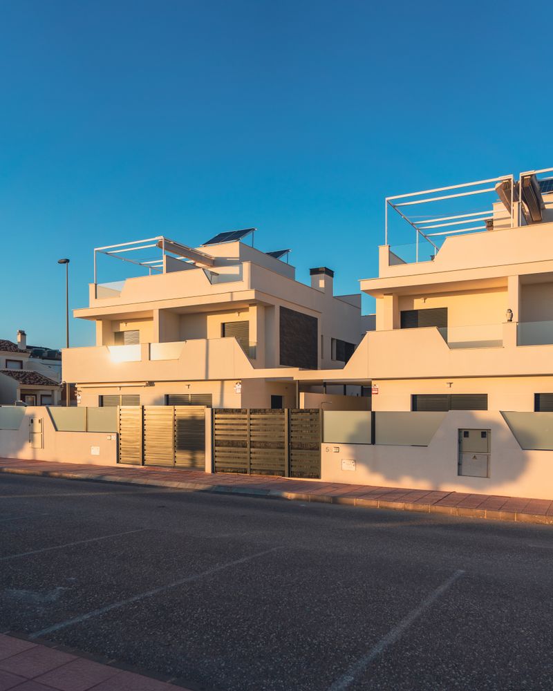 A terrace of contemporary houses lit by late sun — photo by Jakub Pabis on Pexels