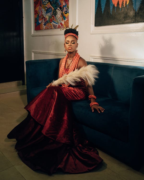 A woman in a red dress sitting on a couch