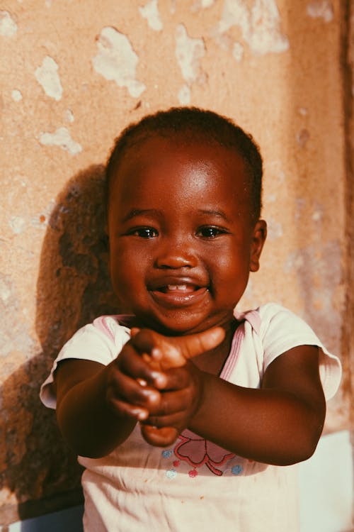 A smiling child with a hand up