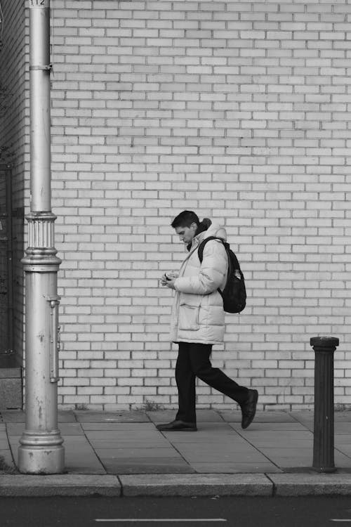 A man walking down the street with his phone