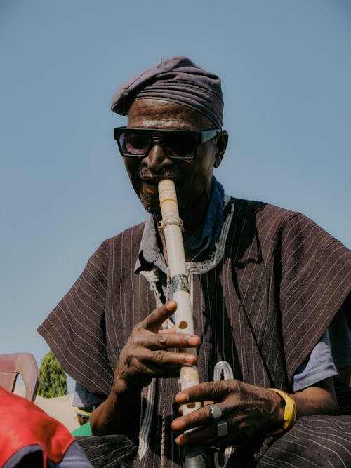 A man in traditional clothing playing a flute