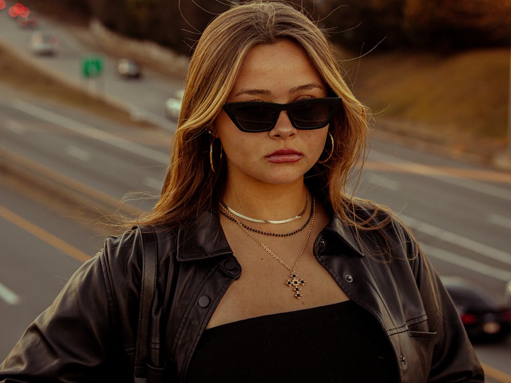 Blonde girl with black leather clothes and shades 