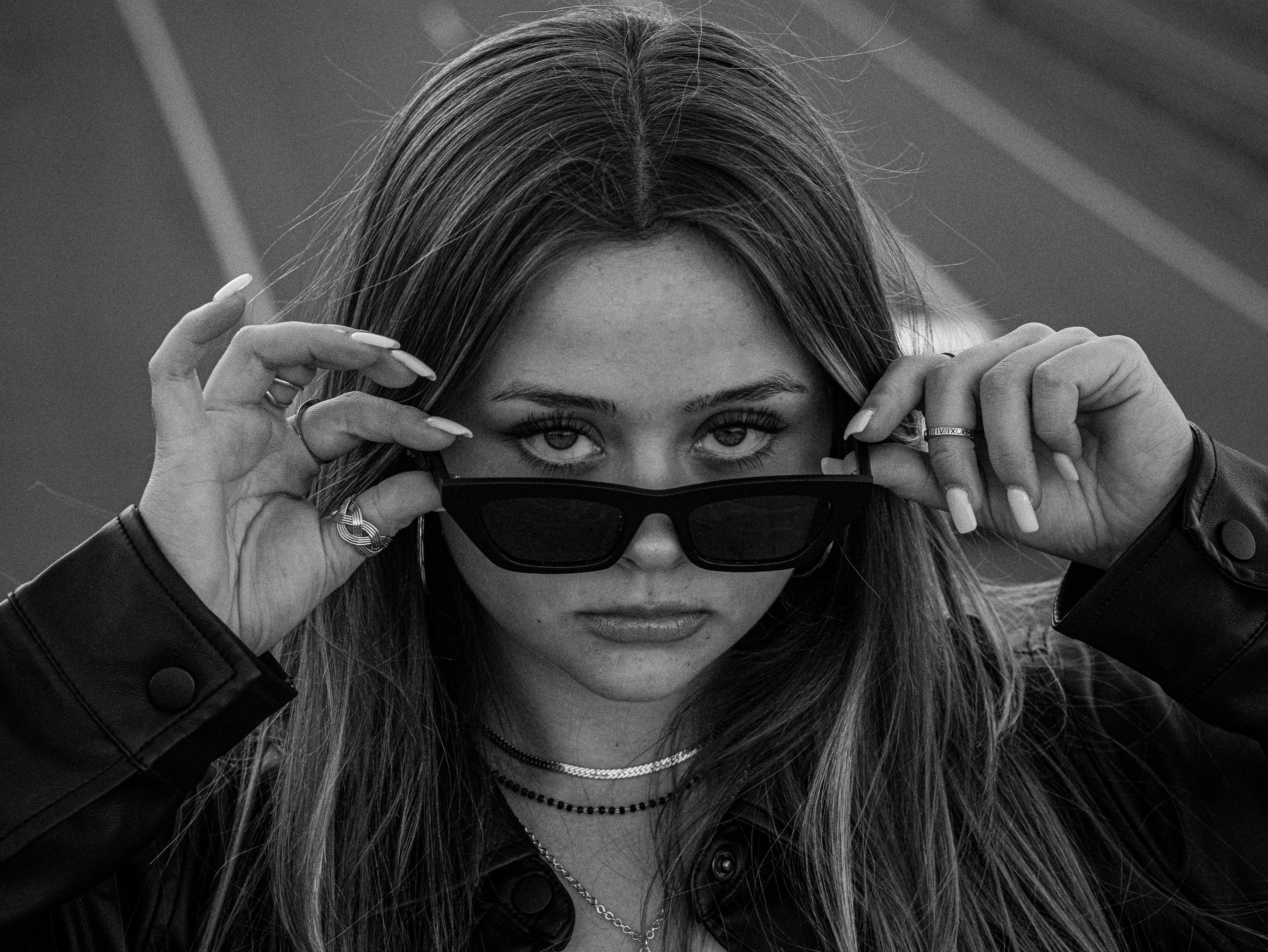 a woman in sunglasses standing on a road