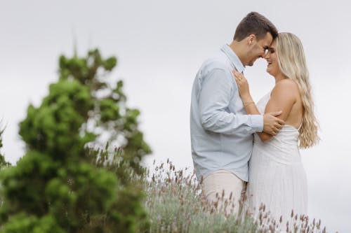 A couple embracing in front of lavender bushes