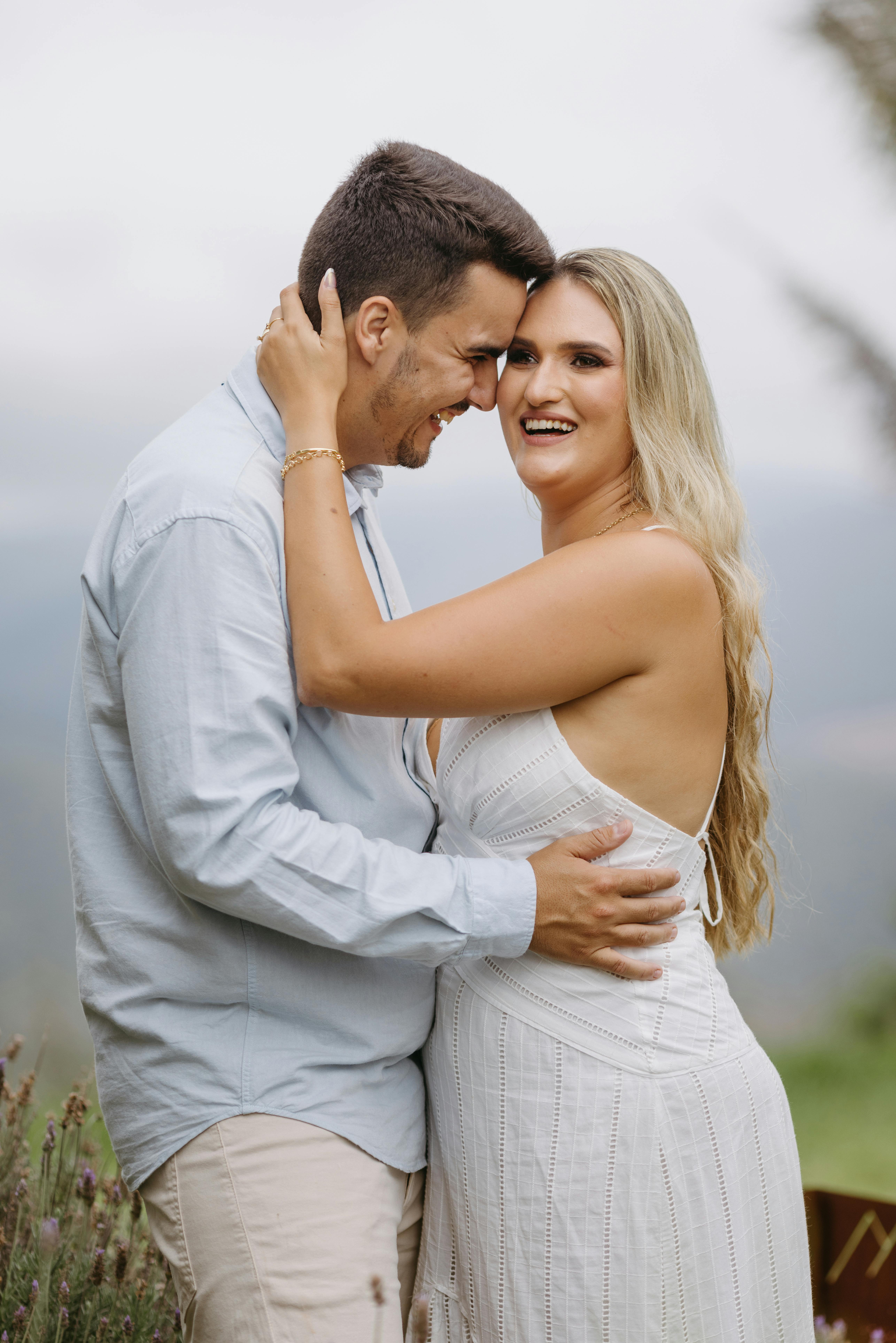 A joyful couple embracing outdoors, capturing a loving moment in a scenic setting.