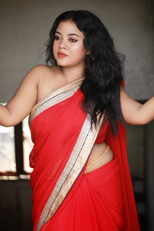 A woman in red sari posing for the camera
