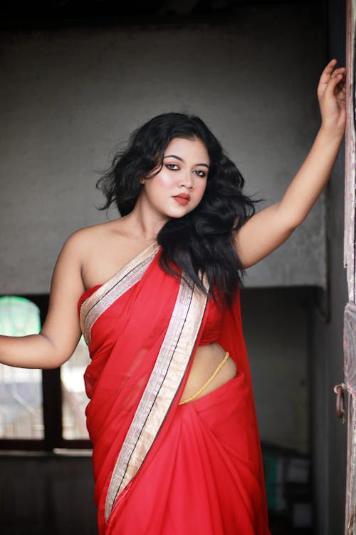 A beautiful woman in red sari posing for the camera