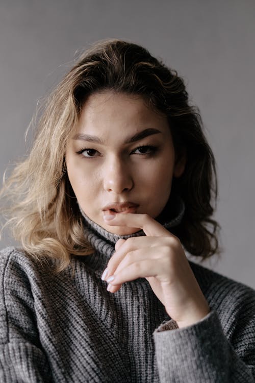 A woman in a turtle neck sweater posing for a portrait