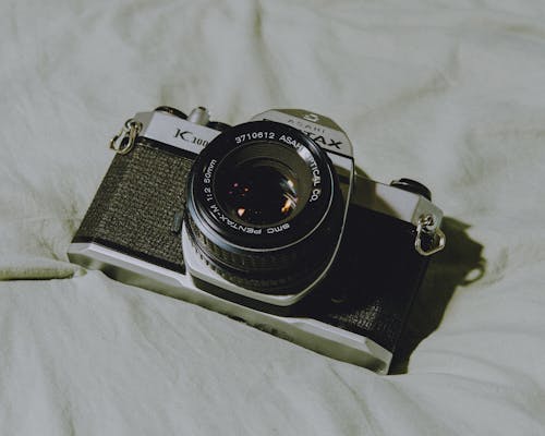 A camera on a bed with a white background