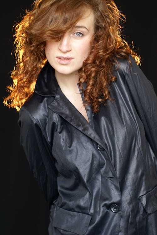 A woman with red hair and a black jacket