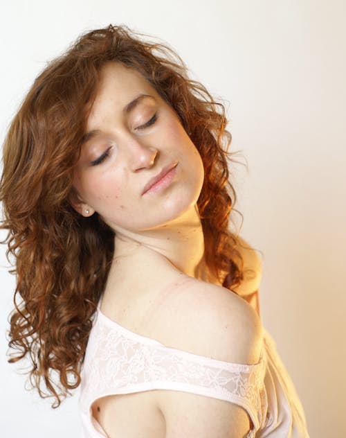 A woman with red hair and a white shirt