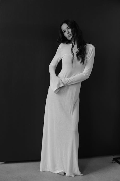 A woman in a long white dress posing for a photo