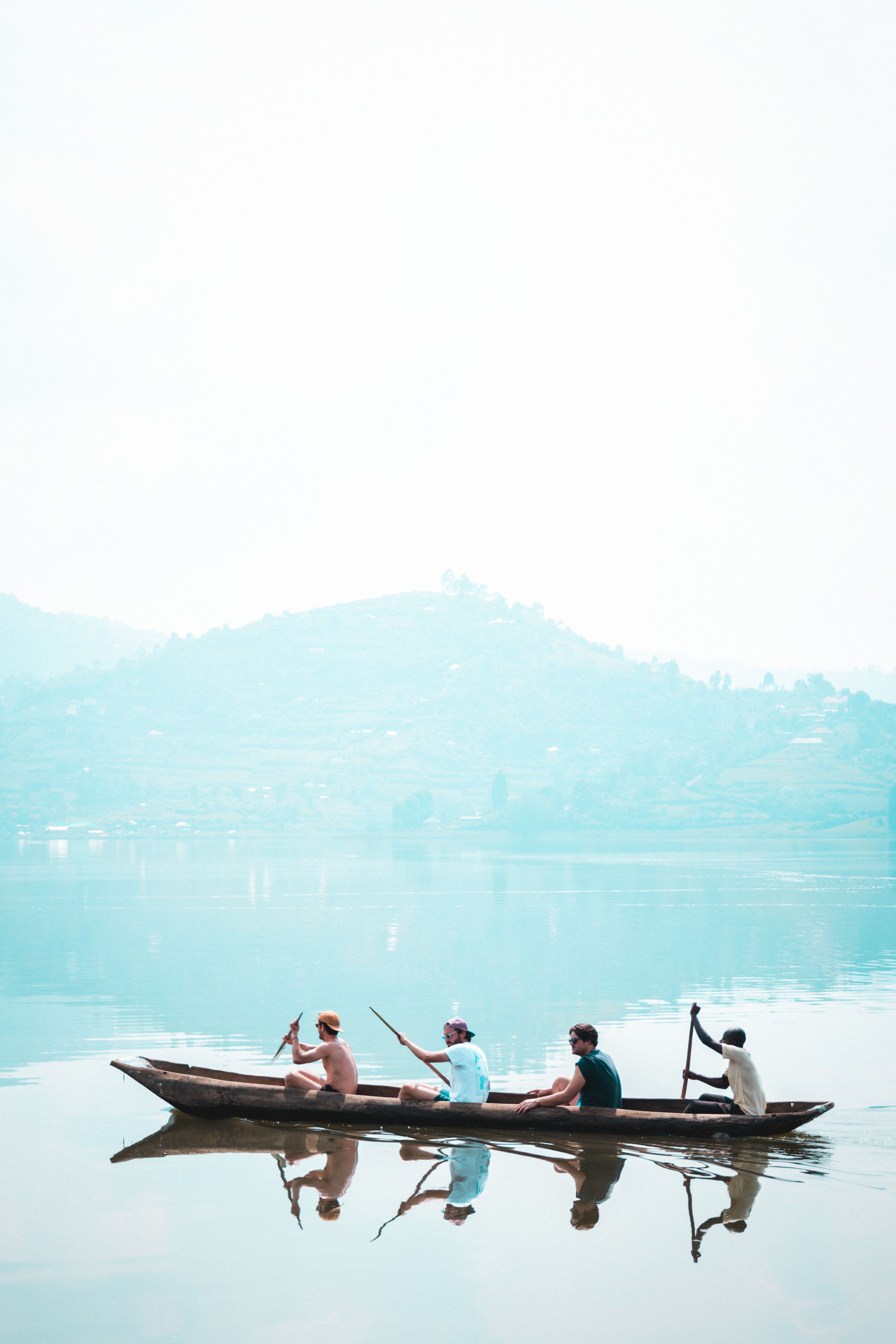 Three people in a boat on a lake · Free Stock Photo