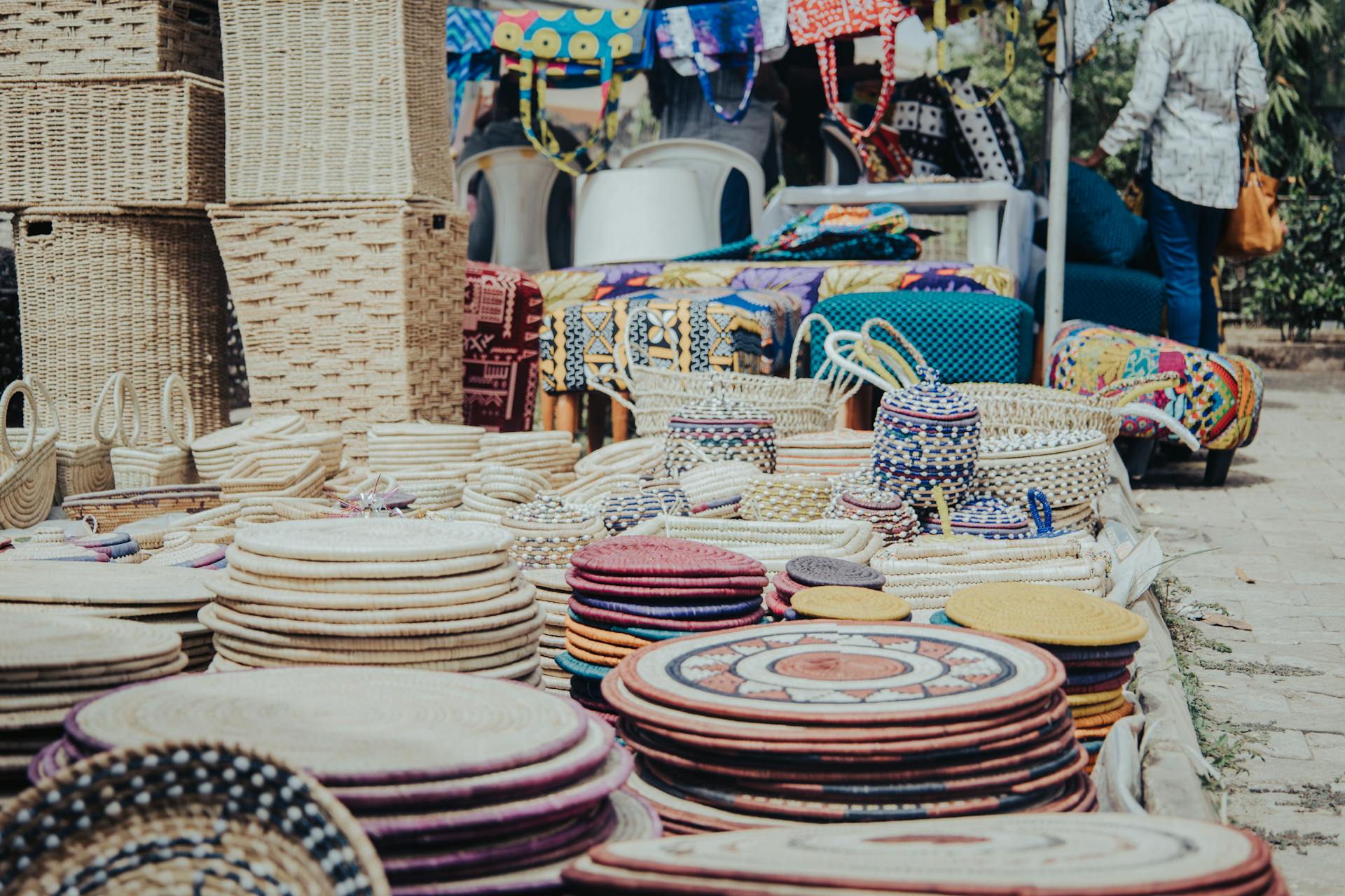Colorful handmade baskets and trays displayed at an outdoor market in Abuja, Nigeria.