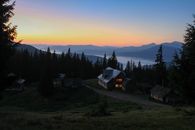 黄昏时分，日落为绿树环绕的宁静山间小屋增添了勃勃生机