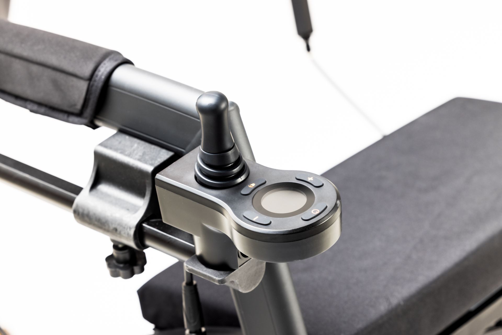 Close-up of an electric wheelchair joystick on a white background, showcasing modern assistive technology.