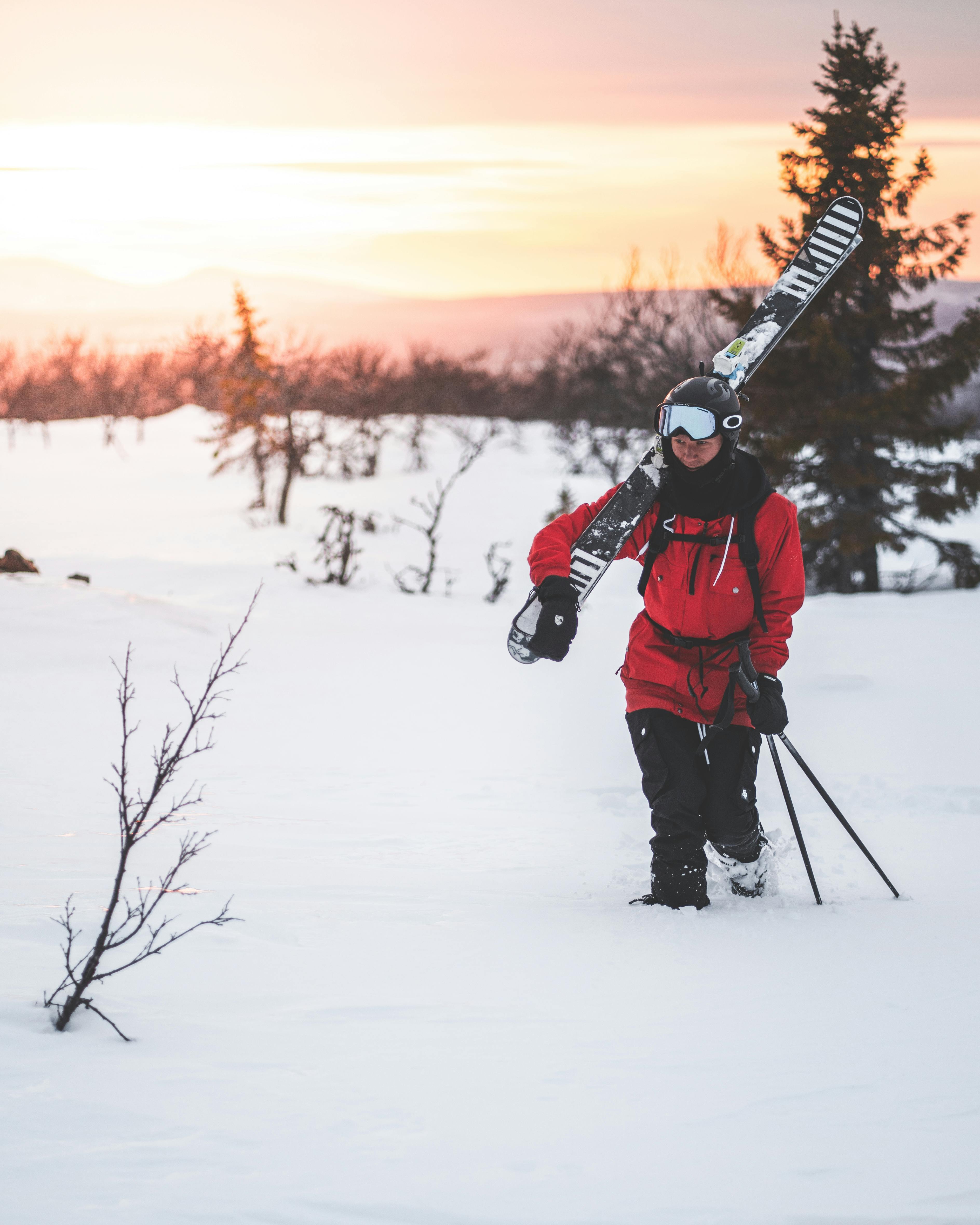 Person Walking on Snow Carrying Ski Boards · Free Stock Photo