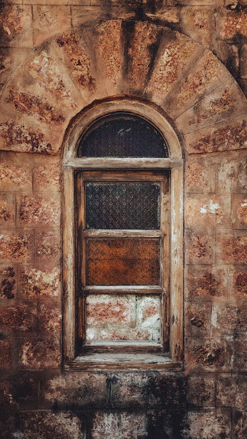 An old window with a stone wall behind it