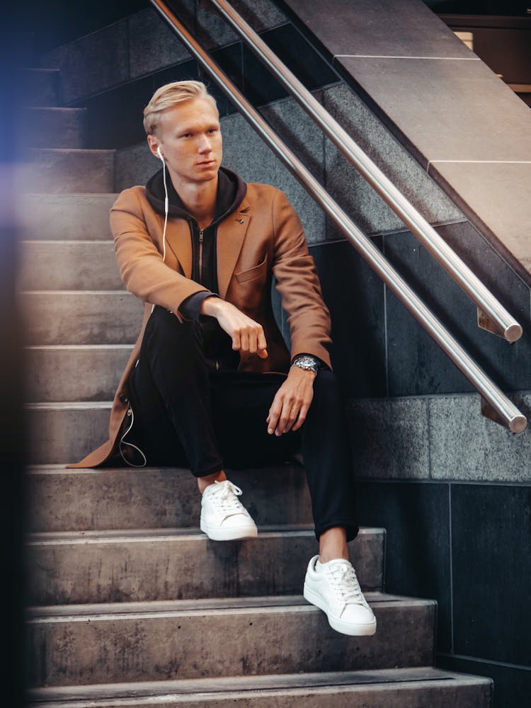 Man In Brown Coat And Black Pants Sitting On Stair