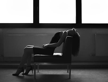 窗前椅子上，一名女子摆出引人注目的单色轮廓姿势