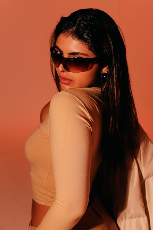 A woman in a tan top and sunglasses